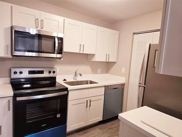 kitchen featuring white cabinetry, appliances with stainless steel finishes, light countertops, and a sink