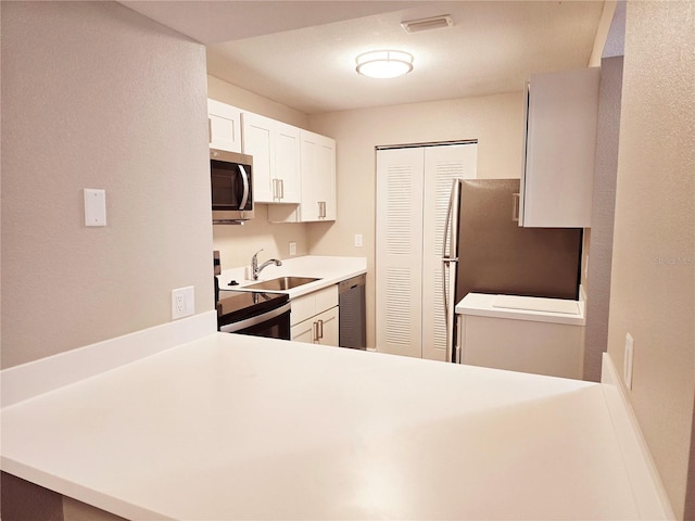 kitchen with visible vents, white cabinets, appliances with stainless steel finishes, light countertops, and a sink