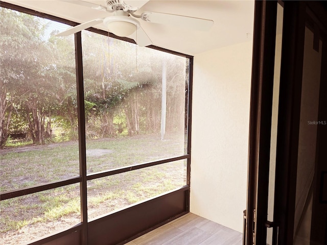 unfurnished sunroom featuring ceiling fan