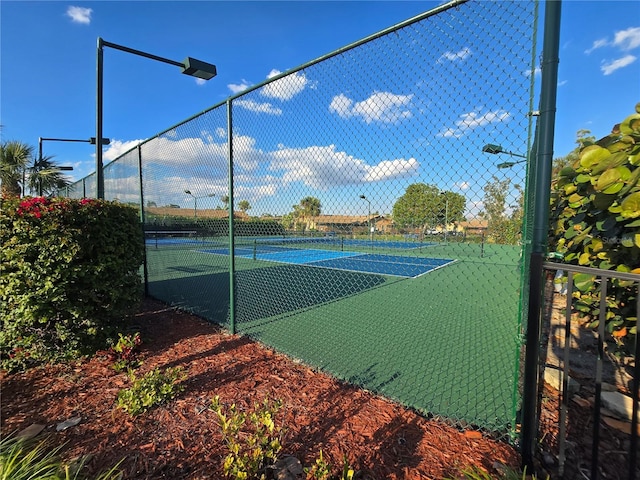 view of tennis court featuring fence