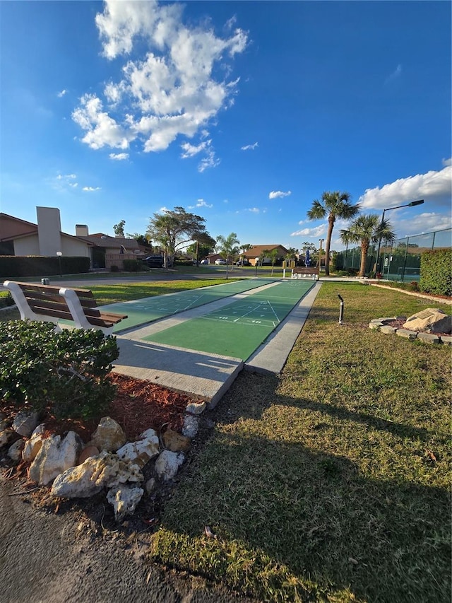 view of home's community with shuffleboard and a lawn