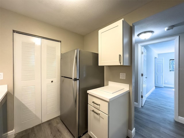 17426 Birchwood Ln Unit 3, Fort Myers, FL 33908 - kitchen with freestanding refrigerator, dark wood-type flooring, light countertops, white cabinets, and a textured ceiling