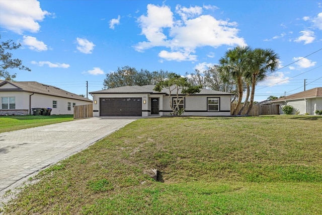 view of front facade featuring a front lawn, decorative driveway, an attached garage, and fence