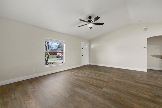 unfurnished room with lofted ceiling, arched walkways, wood finished floors, a ceiling fan, and baseboards