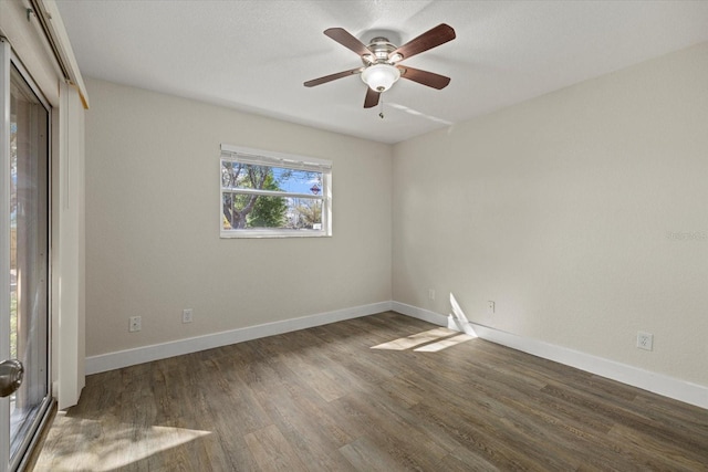 spare room featuring wood finished floors, a ceiling fan, and baseboards