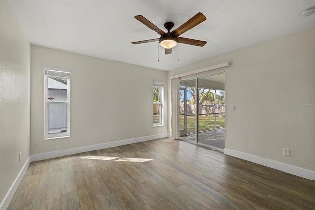 unfurnished room featuring a textured wall, ceiling fan, baseboards, and wood finished floors