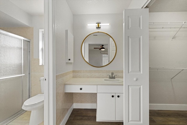 bathroom featuring toilet, a shower stall, wood finished floors, and vanity