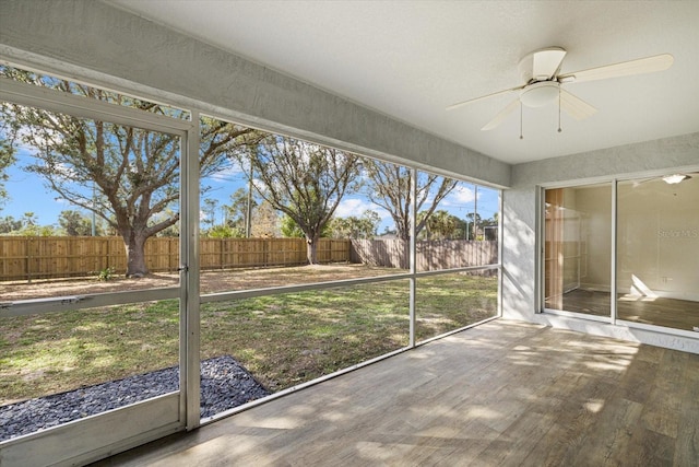 unfurnished sunroom featuring ceiling fan