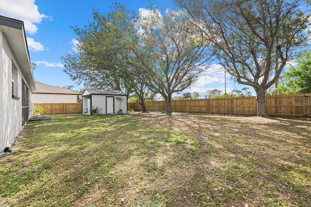 view of yard with a fenced backyard, an outdoor structure, and a shed