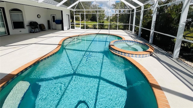 view of swimming pool with glass enclosure, a pool with connected hot tub, and a patio