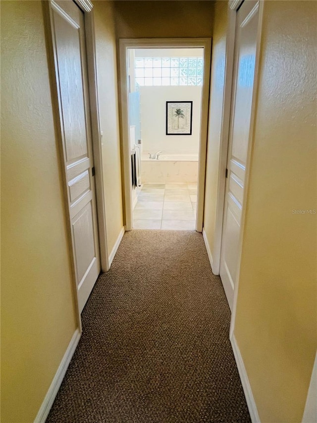 corridor with light carpet and baseboards