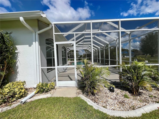 property entrance with a patio area, an outdoor pool, and stucco siding