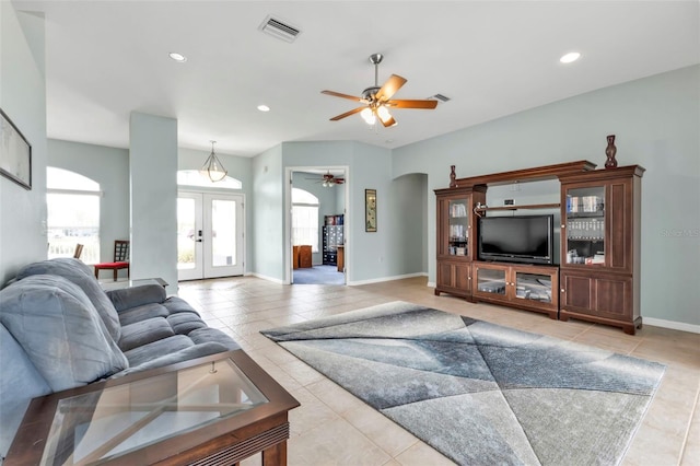 living area featuring arched walkways, french doors, visible vents, and light tile patterned flooring