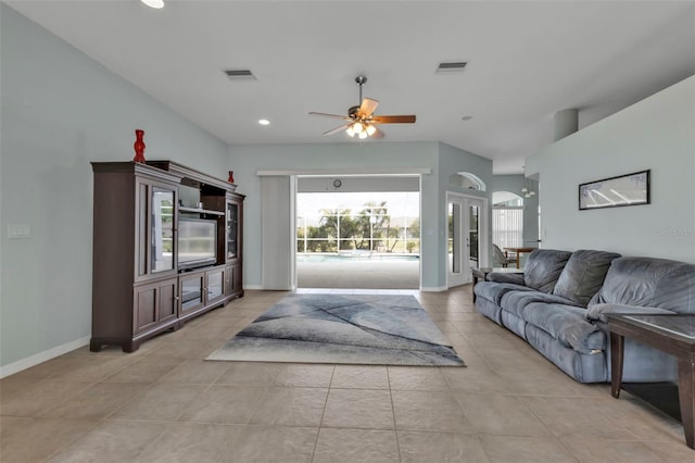 living area featuring a ceiling fan, visible vents, baseboards, and light tile patterned flooring