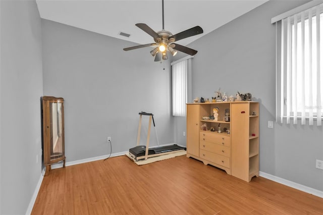 interior space with light wood-type flooring, baseboards, multiple windows, and visible vents