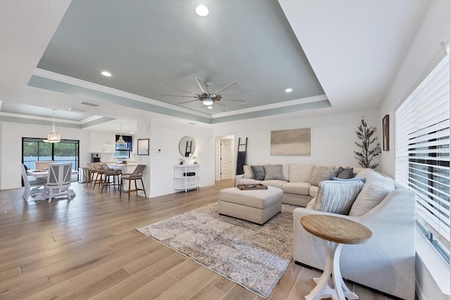 14325 Mcfarland Ave, Port Charlotte, FL 33981 - living room featuring a raised ceiling, a ceiling fan, light wood-style flooring, crown molding, and recessed lighting