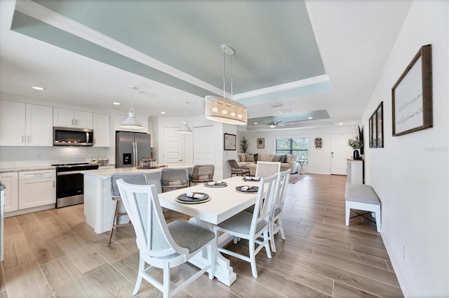 14325 Mcfarland Ave, Port Charlotte, FL 33981 - dining room with a tray ceiling, recessed lighting, light wood finished floors, ceiling fan, and ornamental molding