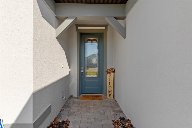 doorway to property featuring stucco siding