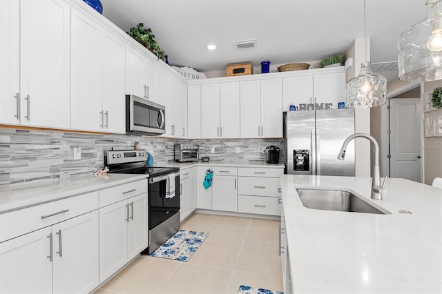 kitchen with light tile patterned flooring, a sink, visible vents, light countertops, and appliances with stainless steel finishes