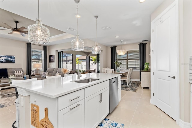 kitchen with a sink, open floor plan, stainless steel dishwasher, and light tile patterned flooring