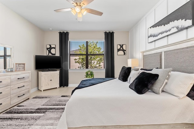 bedroom featuring baseboards, a ceiling fan, and light tile patterned flooring