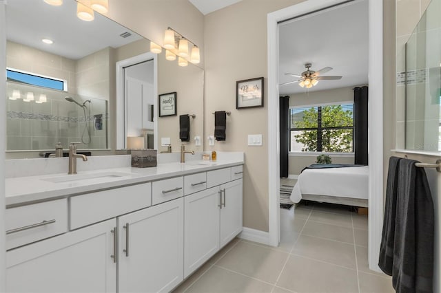 full bath with ceiling fan, a sink, a tile shower, tile patterned floors, and double vanity