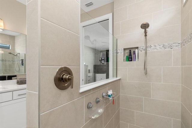 bathroom with visible vents, walk in shower, and vanity