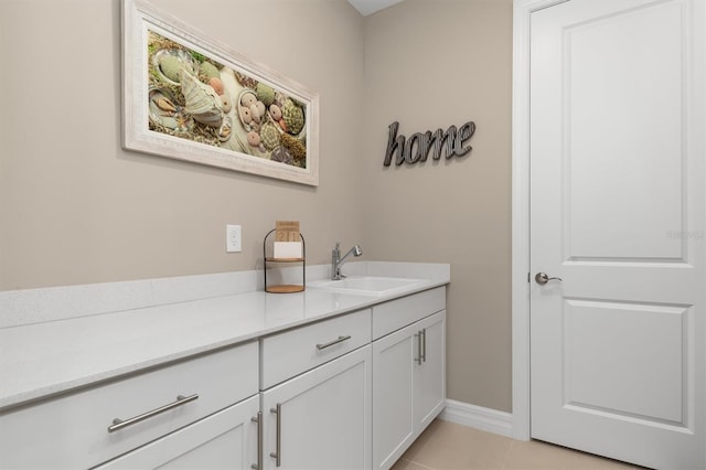 bathroom with tile patterned flooring, baseboards, and vanity