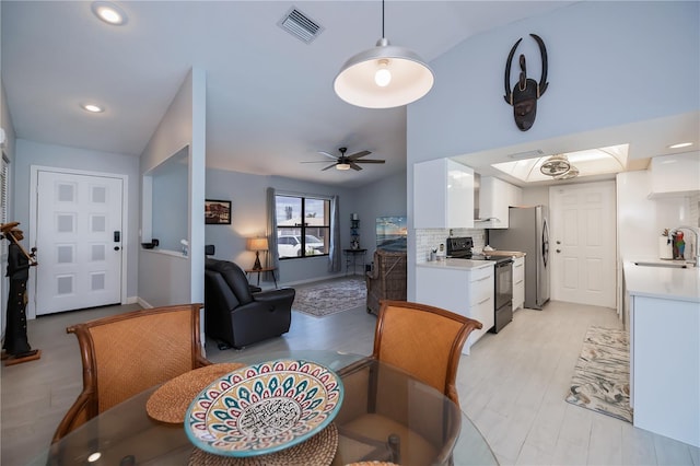 dining area featuring light wood finished floors, visible vents, a ceiling fan, vaulted ceiling, and recessed lighting