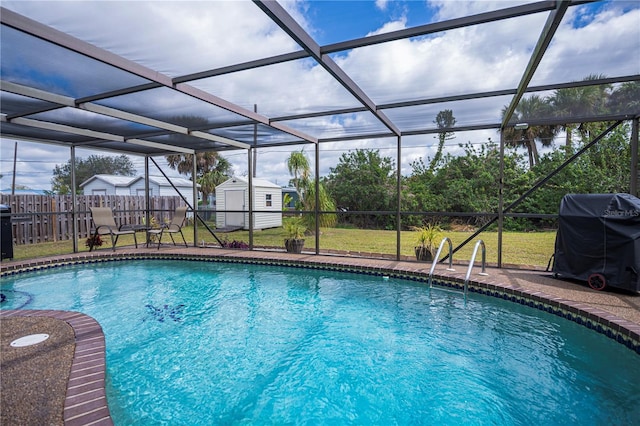 view of swimming pool featuring an outbuilding, glass enclosure, fence, grilling area, and a shed