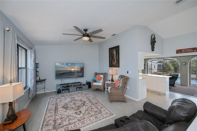 living room featuring a ceiling fan, vaulted ceiling, and wood finished floors