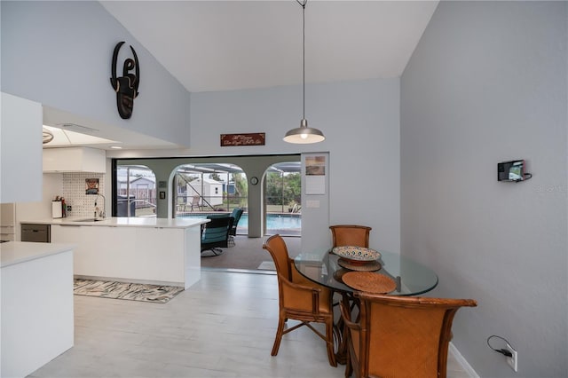 dining room with a high ceiling and light wood finished floors