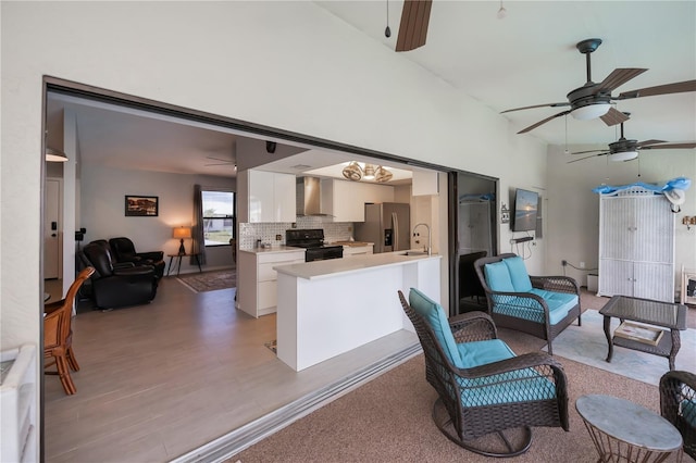 interior space with a towering ceiling, light wood-style floors, and ceiling fan