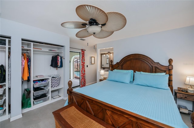 bedroom featuring finished concrete flooring, multiple closets, visible vents, and a ceiling fan