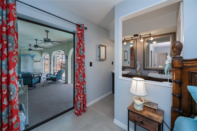 bathroom with ceiling fan and baseboards