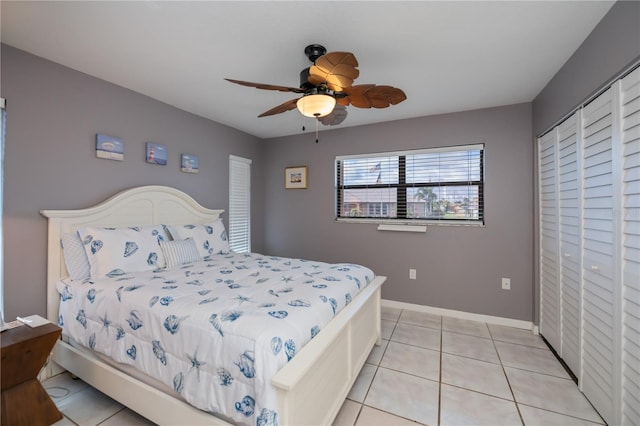 bedroom with light tile patterned floors, ceiling fan, and baseboards