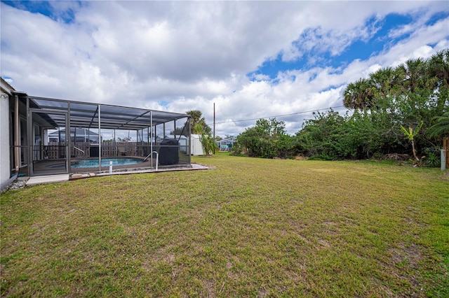 view of yard with glass enclosure and an outdoor pool