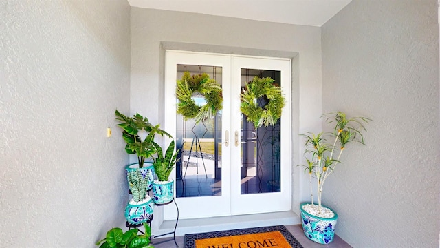 entrance to property featuring french doors and stucco siding