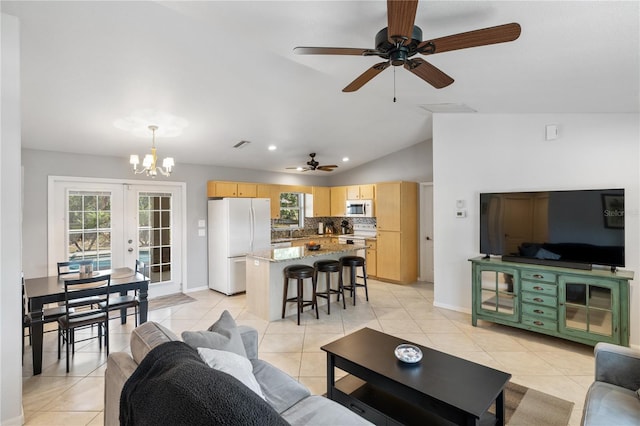 living area with a wealth of natural light, french doors, vaulted ceiling, and light tile patterned floors