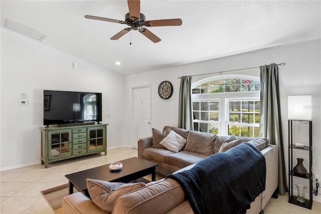 living room with light tile patterned floors, attic access, baseboards, ceiling fan, and vaulted ceiling