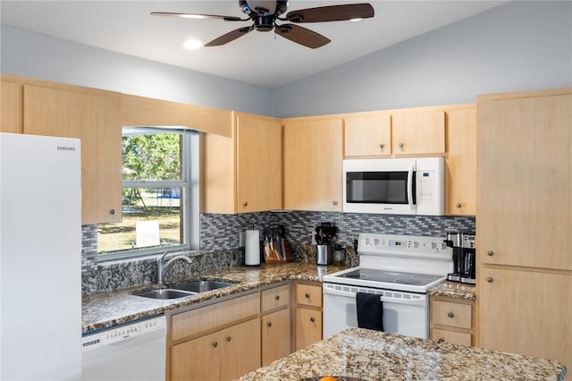 kitchen with white appliances, light brown cabinets, and a sink