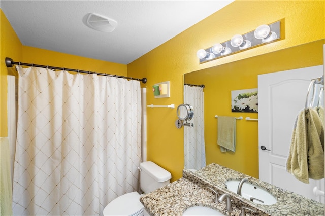 bathroom with a textured ceiling, a textured wall, toilet, a shower with shower curtain, and vanity