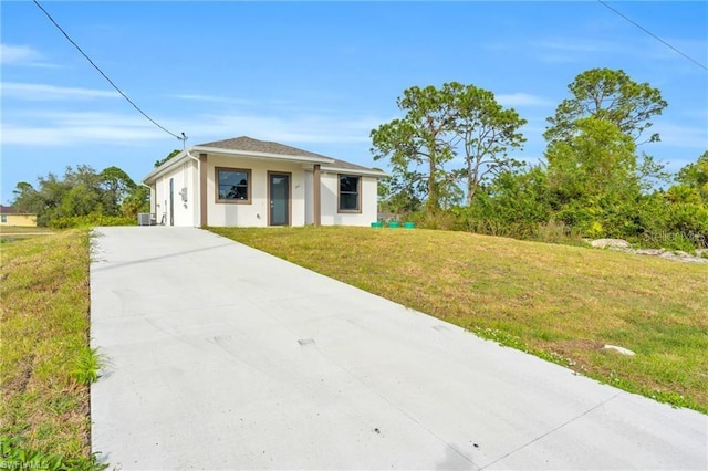 view of front of property with a front yard, driveway, and stucco siding