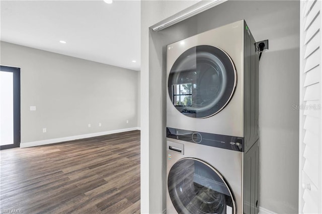 washroom with wood finished floors, baseboards, laundry area, recessed lighting, and stacked washer and clothes dryer