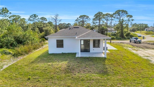 back of property featuring a patio area, stucco siding, a yard, and roof with shingles