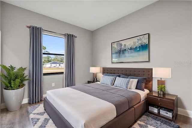 bedroom with baseboards and wood finished floors