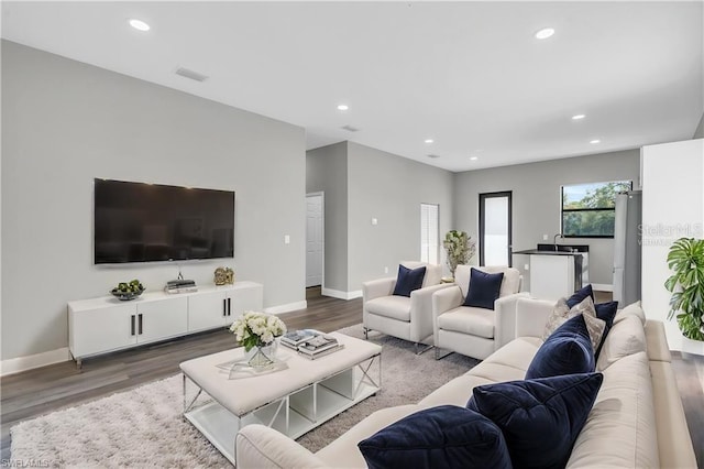 living room with recessed lighting, baseboards, and wood finished floors