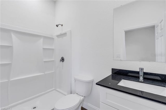 full bathroom with a stall shower, toilet, and vanity