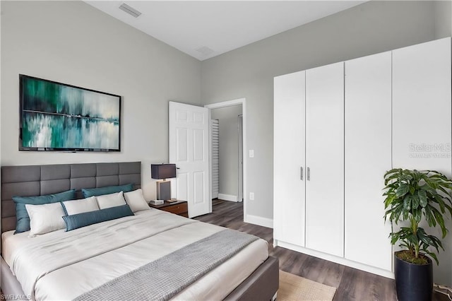 bedroom featuring baseboards, visible vents, and dark wood-style flooring