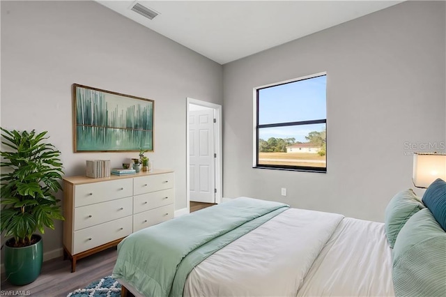 bedroom featuring wood finished floors, visible vents, and baseboards